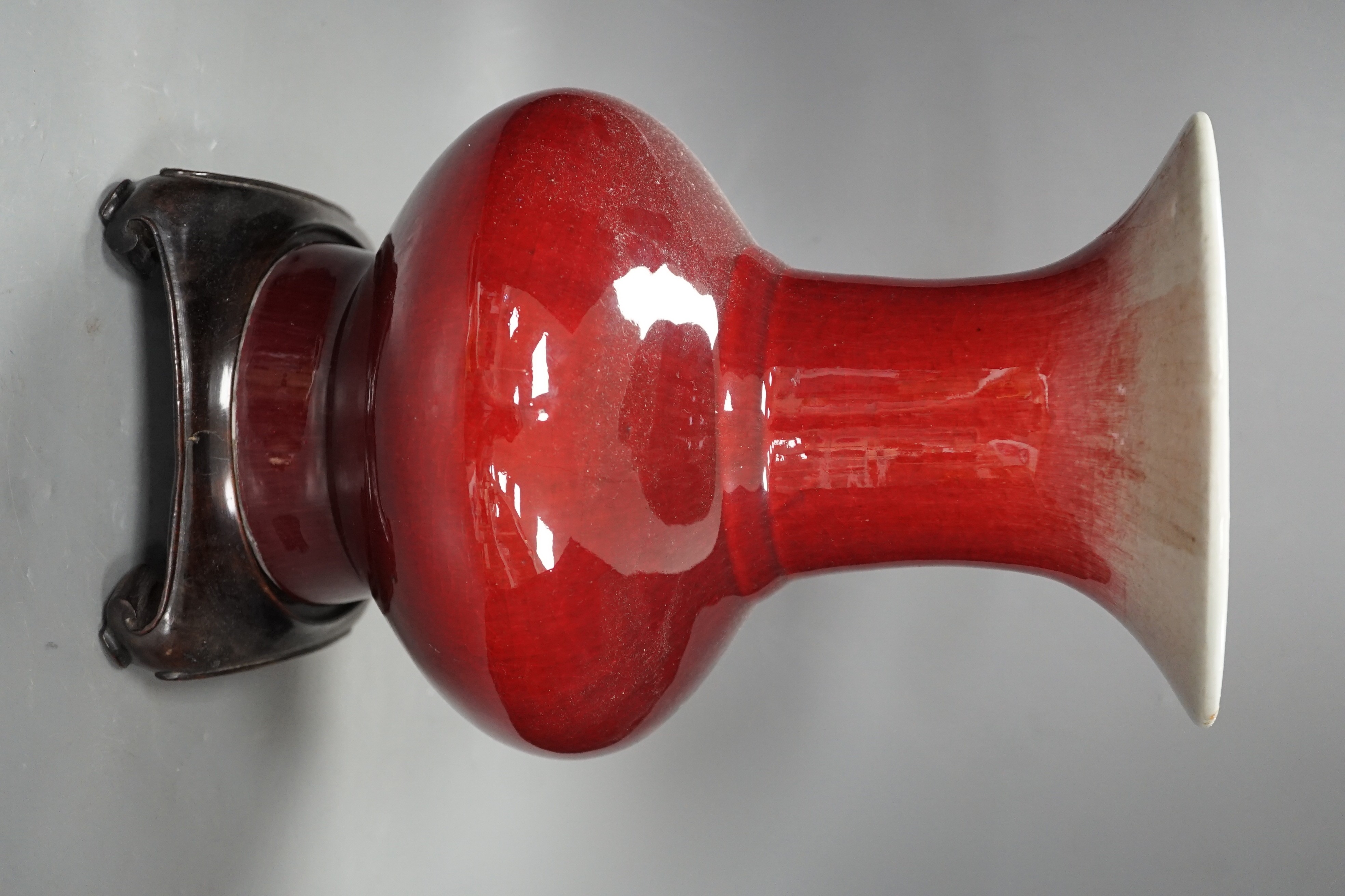 A 19th century Chinese sang de boeuf vase of squat baluster form with everted rim (a.f.), on square hardwood stand, overall 35.5cm high